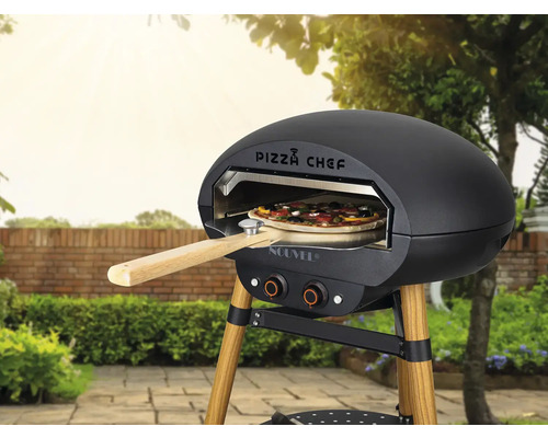 Four à pizza avec pizza et pelle à pizza à l'extérieur