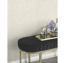 Szene mit einer strukturierten Tapete, einer schwarzen Bank mit goldenem Gestell, einem goldenen Tablett mit Kerzen und einer Blumenvase.
