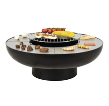 Table de barbecue ronde avec grille, aliments grillés et ingrédients