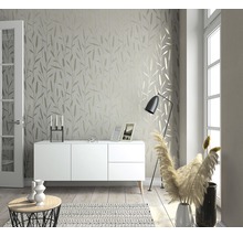 Heller Wohnraum mit Tapete mit Blattmuster, Sideboard, Stehlampe und Dekoration