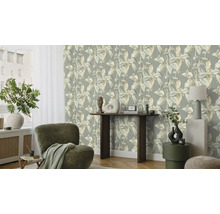 Salon avec papier peint à motifs de feuilles, fauteuil et décoration