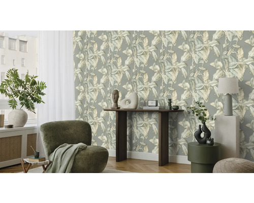Salon avec papier peint à motifs de feuilles, fauteuil et décoration
