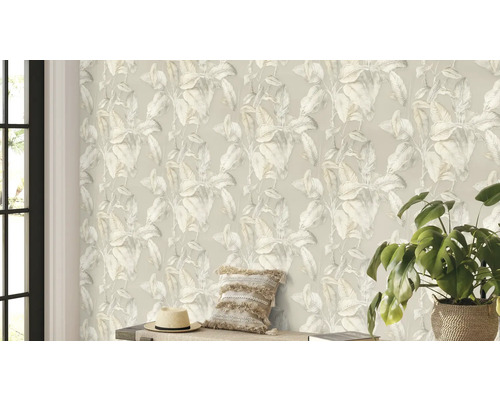 Espace de vie avec un papier peint à motif de plantes, un coussin, un chapeau et une plante d'intérieur.