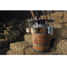 Baril à vin avec verres, paniers et seau à glace devant des bottes de foin