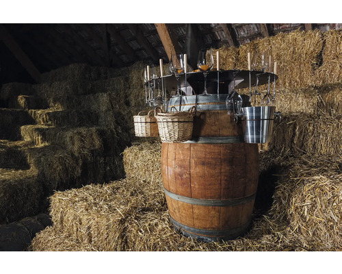 Baril à vin avec verres, paniers et seau à glace devant des bottes de foin