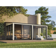 Véranda moderne avec portes coulissantes, mobilier de salon et plancher en bois sur une pelouse.