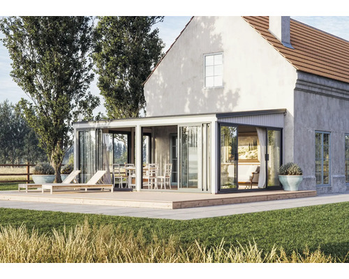 Maison avec terrasse, véranda, mobilier de jardin et pelouse.