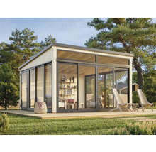 Maison de jardin moderne avec façade en verre et terrasse en bois dans un écrin de verdure.