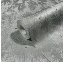 Un rouleau de papier peint intissé structuré avec des pierres décoratives intégrées.