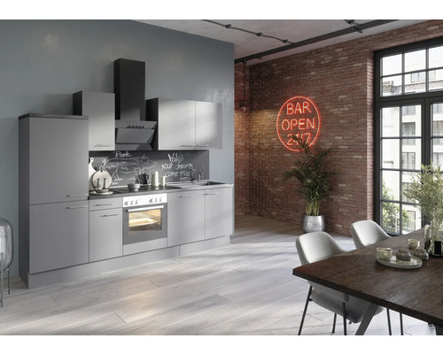 Moderne Küche mit grauen Schränken, Backofen und Dunstabzugshaube vor einer Backsteinwand mit Leuchtreklame