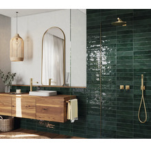 Modernes Badezimmer mit Holzwaschtisch, Spiegel, Hängeleuchte und grünen Fliesen im Duschbereich