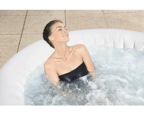 Frau entspannt in einem aufblasbaren Whirlpool im Freien.