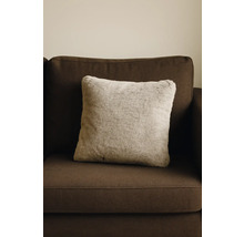 Coussin décoratif carré aspect fourrure sur canapé marron