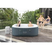 Aufblasbarer Lay-Z-Spa Whirlpool mit zwei Personen im Wasser und zwei Personen in Stühlen daneben auf einer Holzterrasse.