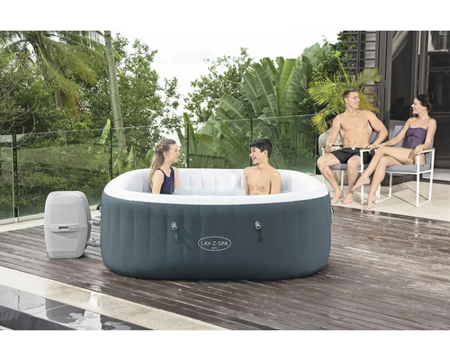 Aufblasbarer Lay-Z-Spa Whirlpool mit zwei Personen im Wasser und zwei Personen in Stühlen daneben auf einer Holzterrasse.