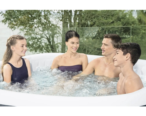 Familie entspannt in einem aufblasbaren Whirlpool im Garten.