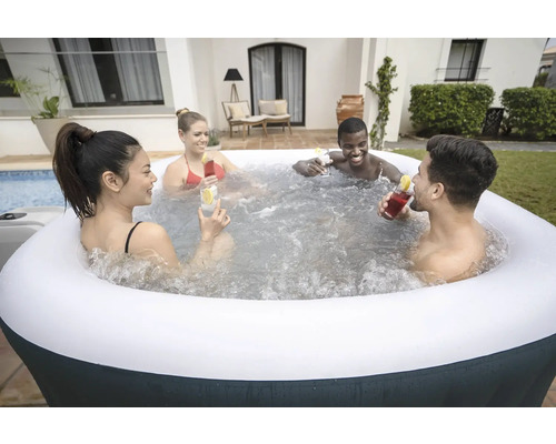 Aufblasbarer Whirlpool mit vier Personen, die Cocktails genießen.