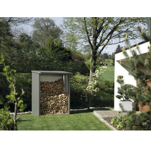 Abri à bois dans le jardin rempli de bois.