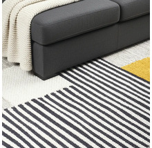 Detailansicht von Sofa und gestreiftem Teppich