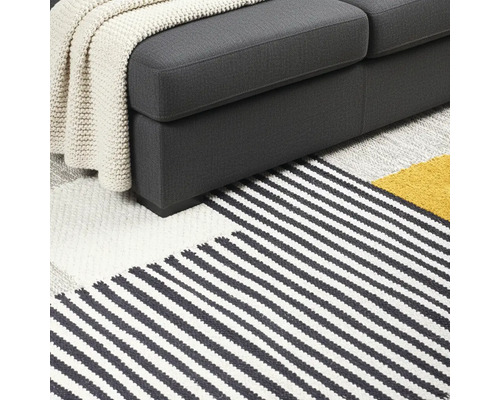 Detailansicht von Sofa und gestreiftem Teppich