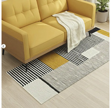 Gelbes Sofa mit geometrischem Teppich im Wohnzimmer