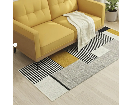 Gelbes Sofa mit geometrischem Teppich im Wohnzimmer