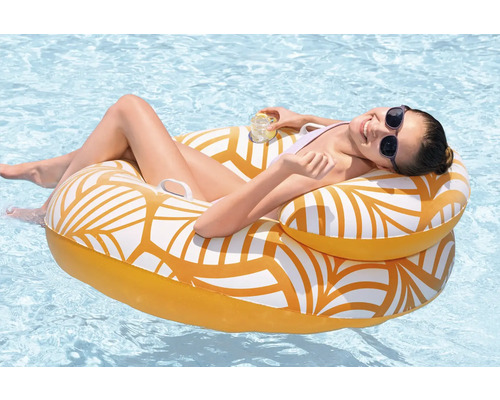 Femme se détend sur un fauteuil de piscine gonflable dans l'eau