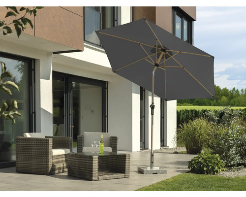 Gartenlounge mit Gartenschirm auf Terrasse vor modernem Haus