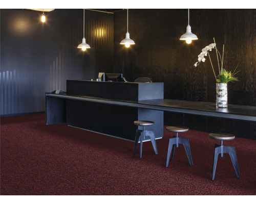 Empfangsbereich mit dunklem Tresen, Stehlampen und Teppichboden