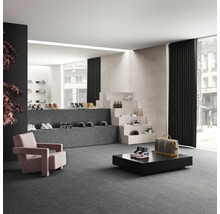 Geräumiger Verkaufsraum mit Schuhen, Sesseln und dekorativer Treppe