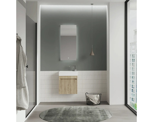Salle de bains lumineuse avec lavabo, miroir et tapis
