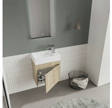 Salle de bain moderne avec lavabo, miroir, lampe et panier à linge.