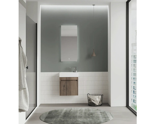 Salle de bains moderne avec lavabo, miroir, panier à serviettes et tapis rond