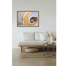 Gerahmtes Wandbild einer Wendeltreppe über einem Sofa im Wohnzimmer.