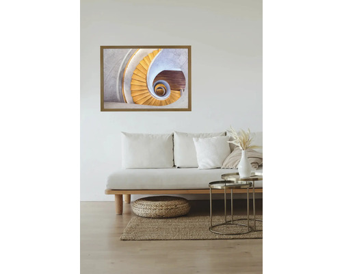 Gerahmtes Wandbild einer Wendeltreppe über einem Sofa im Wohnzimmer.