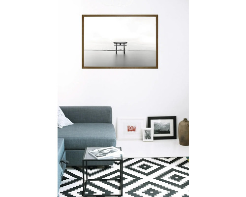 Wohnraum mit Sofa, Tisch und gerahmtem Bild einer Torii im Wasser