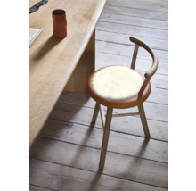 Tabouret en bois avec revêtement en fourrure à côté d'une table en bois