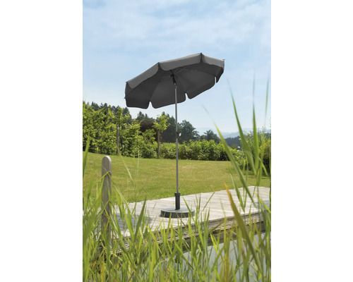 Grauer Sonnenschirm auf einer Holzterrasse im Garten.