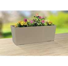 Jardinière beige avec des fleurs jaunes et roses sur une table