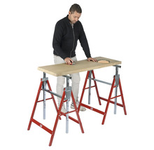 Un homme ponce une planche en bois sur deux tréteaux pliants rouges et argentés