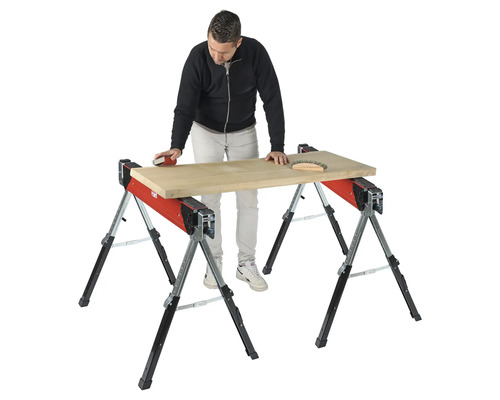 Artisan ponçant une planche de bois sur deux tréteaux