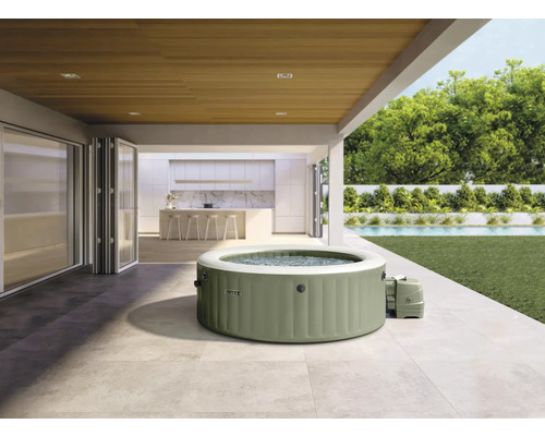 Bain à remous Intex sur une terrasse avec maison et jardin à l'arrière-plan