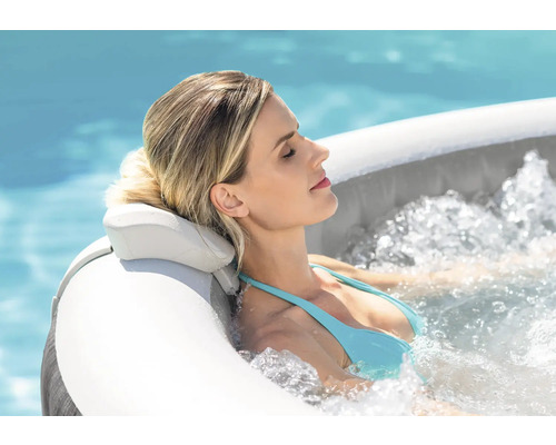 Une femme se détend dans un bain à remous à l'extérieur