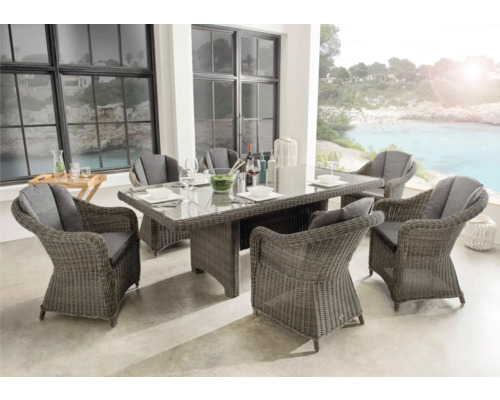 Ensemble de meubles de jardin avec six chaises, table et décorations de table sur une terrasse avec vue sur la mer