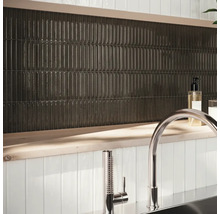 Décoration murale avec des carreaux allongés et foncés et robinetterie