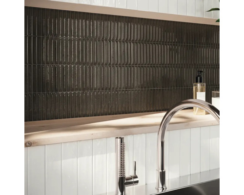 Décoration murale avec des carreaux allongés et foncés et robinetterie