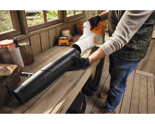 Une personne assemble un souffleur Stihl sur un établi.