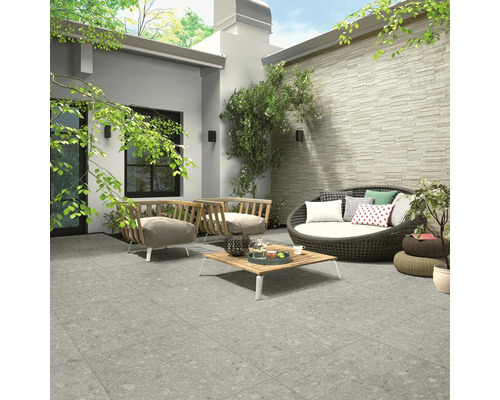 Terrasse mit Bodenfliesen, Sitzmöbeln und dekorativen Elementen