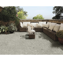 Terrasse mit grauem Plattenboden, Rattansofa und Dekoration