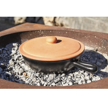 Pot de cuisson en céramique avec couvercle sur charbon de bois
